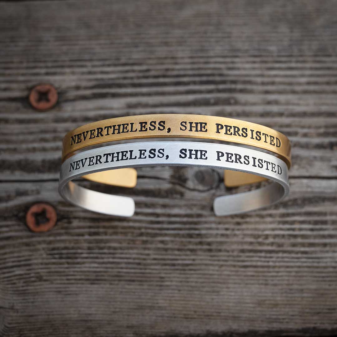 Nevertheless, She Persisted bracelet - perfect science jewelry gift for strong women, graduates, teachers, students, and all women who persist! Made from hand stamped sturdy aluminum or bronze. Bracelets on an aged brown wood background.