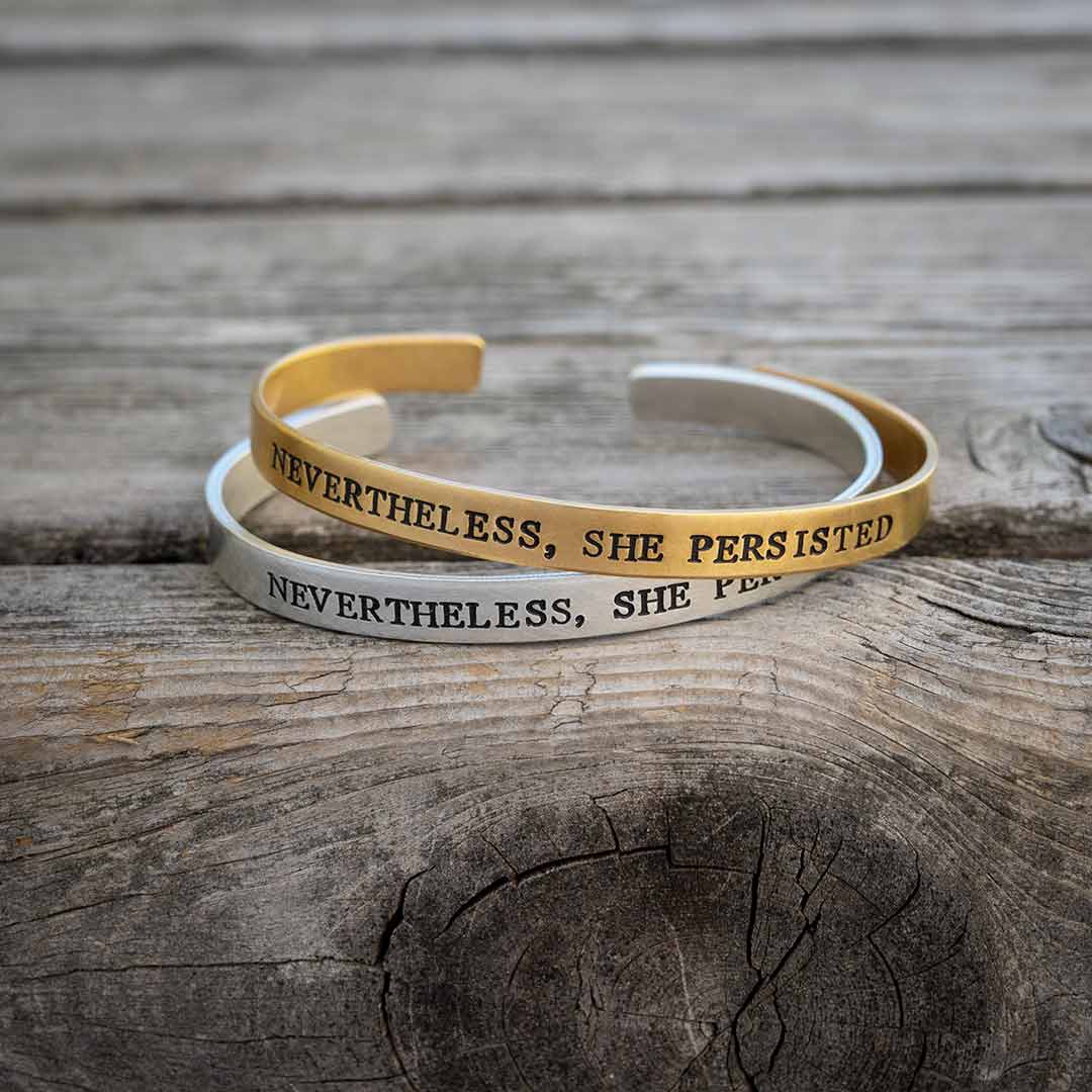 Nevertheless, She Persisted bracelet - perfect science jewelry gift for strong women, graduates, teachers, students, and all women who persist! Made from hand stamped sturdy aluminum or bronze. Bracelets on an aged brown wood background.