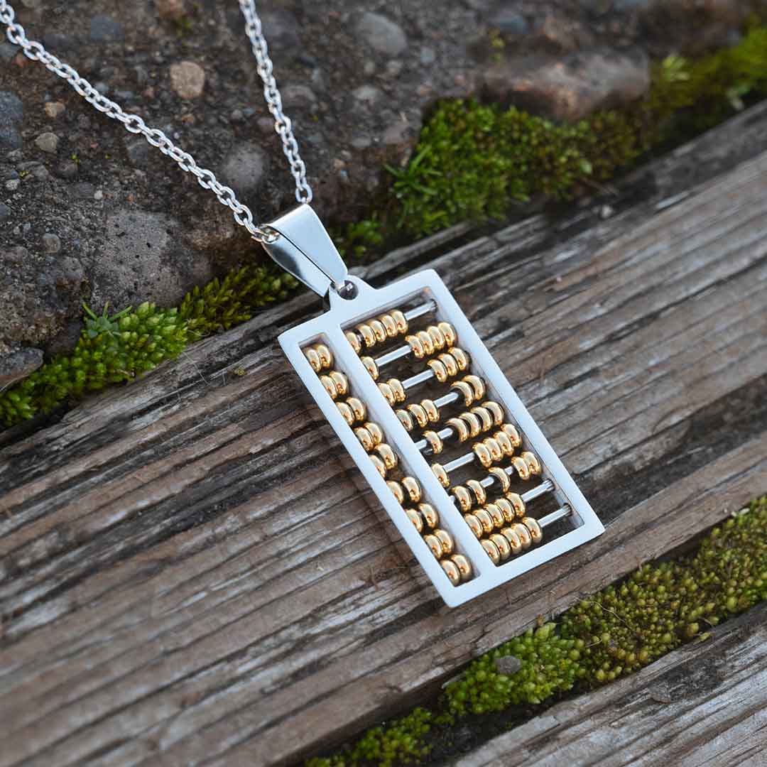 Abacus Necklace - Great science jewelry gift for a mathematician, math teacher, or student! Steel pendant measures 1 ¼ inches long and ¾ inch wide with moving gold beads on 24 inch steel link chain.
