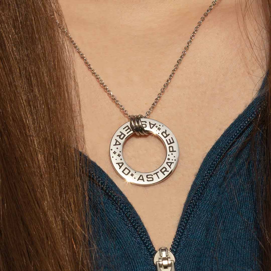 Ad Astra Per Aspera Necklace - Perfect science jewelry gift for space science enthusiasts, astronomy students &amp; instructors, and anyone with a dream to follow, despite the challenges. Steel disc pendant is engraved with the Latin phrase “AD ASTRA PER ASPERA”, which translates as “to the stars, through difficulties”. Each word is framed with tiny stars, and the pendant freely moves within three steel jump rings and is hung on an adjustable 16-18 inch steel chain.