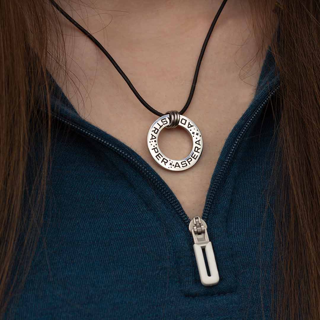 Ad Astra Per Aspera Necklace - Perfect science jewelry gift for space science enthusiasts, astronomy students &amp; instructors, and anyone with a dream to follow, despite the challenges. Steel disc pendant is engraved with the Latin phrase “AD ASTRA PER ASPERA”, which translates as “to the stars, through difficulties”. Each word is framed with tiny stars, and the pendant freely moves within three steel jump rings and is hung on an adjustable black leather cord.
