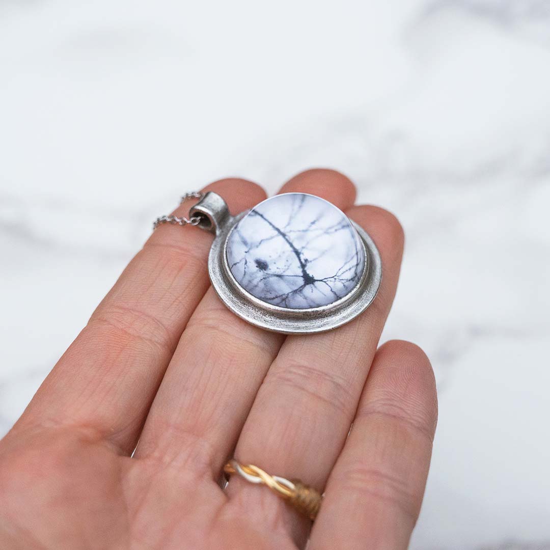 Neuron necklace: science jewelry for biology and neuroscience. Great gift for teachers, biologists, nurses, and neuroscientists. Pyramidal neuron under a glass dome with a steel chain.