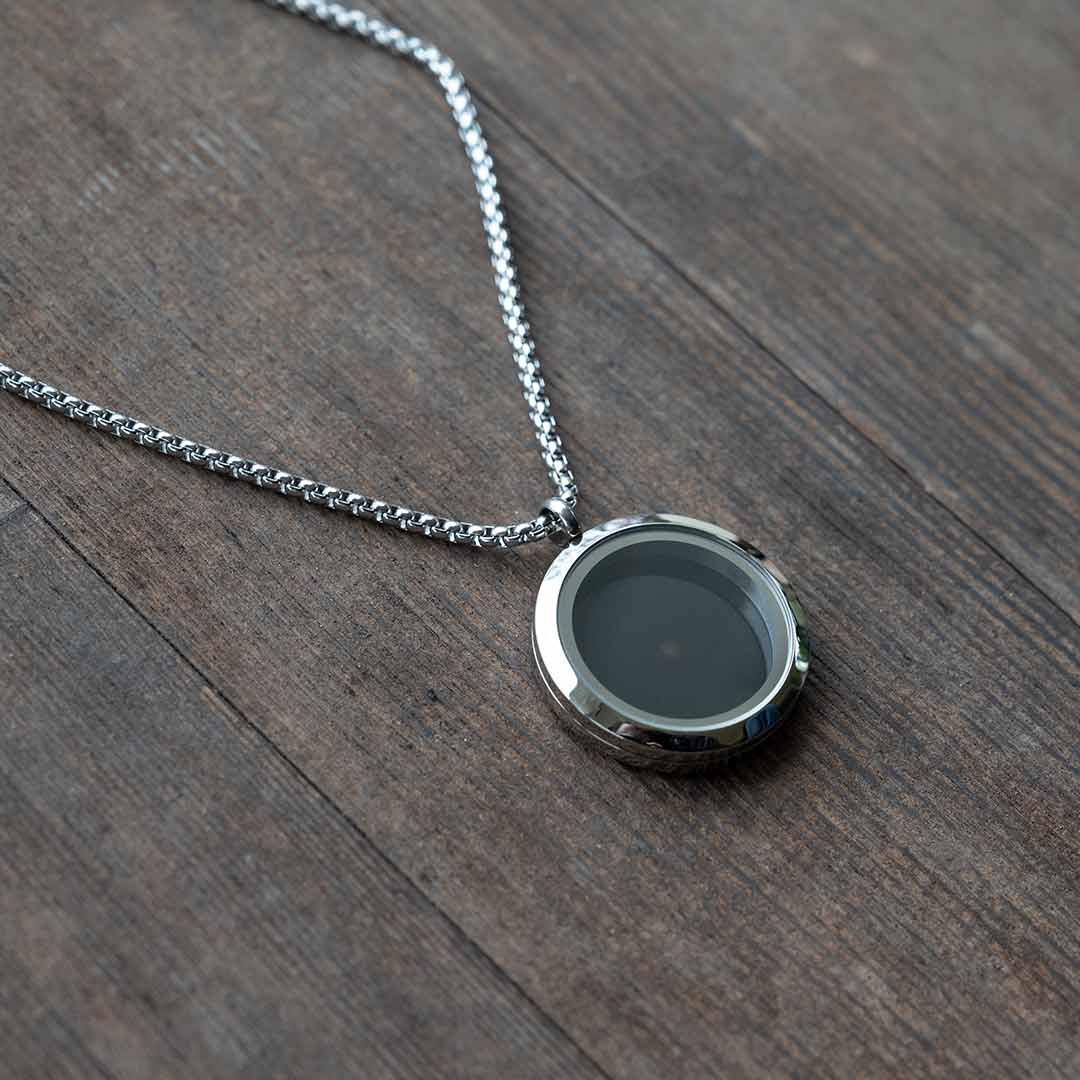 Universe Necklace - science jewelry for astronomers, science teachers, star gazers, and astronomy and space enthusiasts.  This pendant is on a steel chain, on a wooden background.