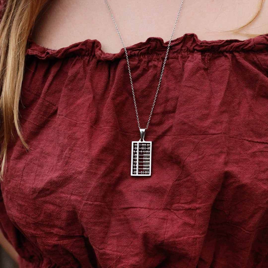 Abacus Necklace - Great science jewelry gift for a mathematician, math teacher, or student! Steel pendant measures 1 ¼ inches long and ¾ inch wide with moving steel beads on 24 inch steel link chain.