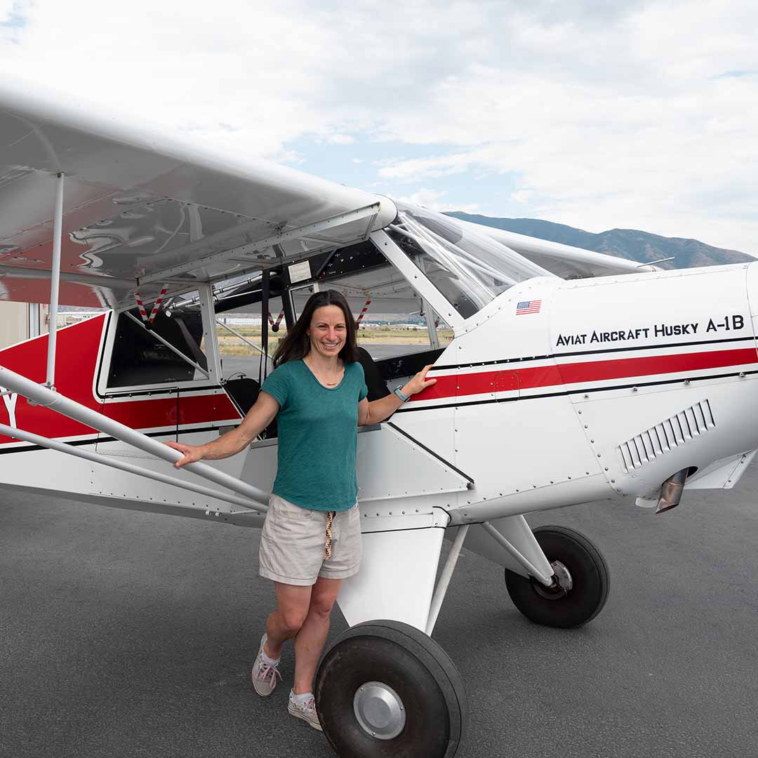 Woman wearing ALIS VOLAT PROPRIIS Necklace in front of an airplane