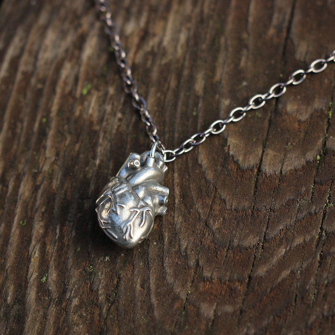 Pewter Anatomical Heart Necklace - Perfect science jewelry gift for nurses, doctors, med students, cardiologists, medical researchers, science teachers, and lovers. This pewter anatomically correct heart necklace has meticulously correct details, including the aorta, vena cava, pulmonary arteries and veins, and the finely branched coronary blood vessels. Pendant is small batch cast from genuine pewter and given an antique finish and  hung on an 18 inch or 32 inch heavyweight gunmetal chain.