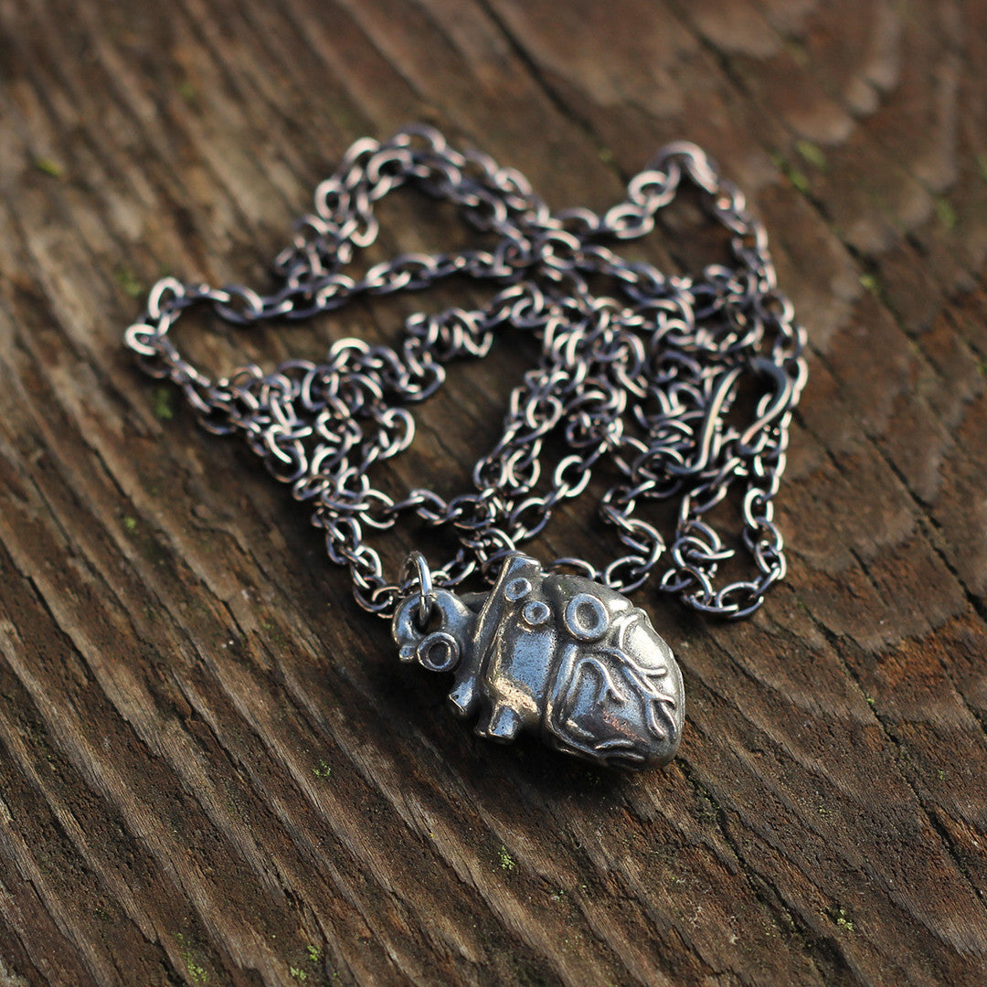 Pewter Anatomical Heart Necklace - Perfect science jewelry gift for nurses, doctors, med students, cardiologists, medical researchers, science teachers, and lovers. This pewter anatomically correct heart necklace has meticulously correct details, including the aorta, vena cava, pulmonary arteries and veins, and the finely branched coronary blood vessels. Pendant is small batch cast from genuine pewter and given an antique finish and  hung on an 18 inch or 32 inch heavyweight gunmetal chain.