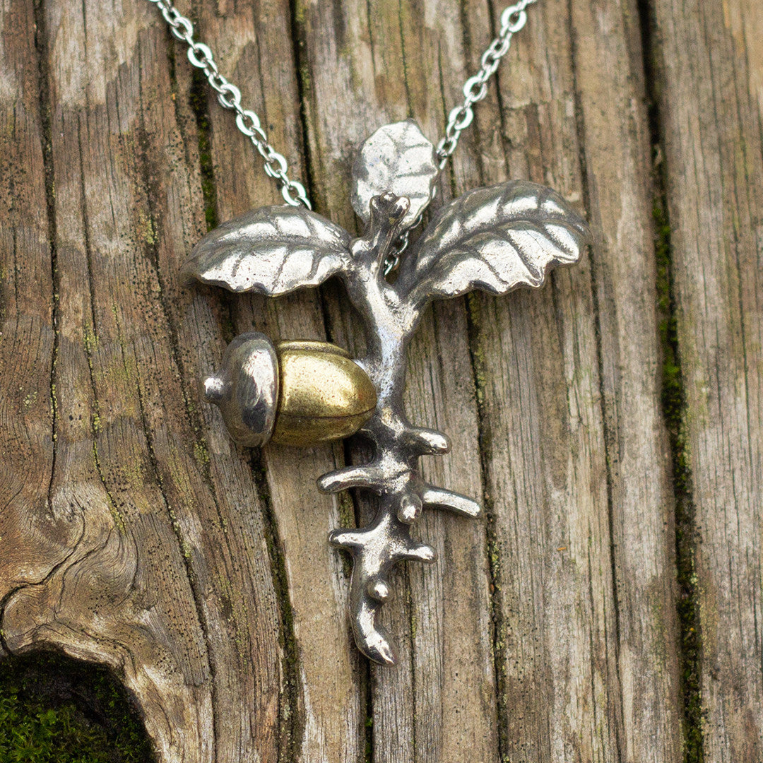 Acorn Necklace - Perfect science jewelry gift for horticulturists, landscape designers, botanists, students, learners, dreamers, doers, teachers, gardeners of plants or of young minds, and anyone who grows, matures, learns, and aspires. Pendant has antiqued brass acorn with antiqued pewter acorn cap, root, and shoot systems. Pendant measures 2" long and 1.5" wide. Hung on a 22" steel chain.