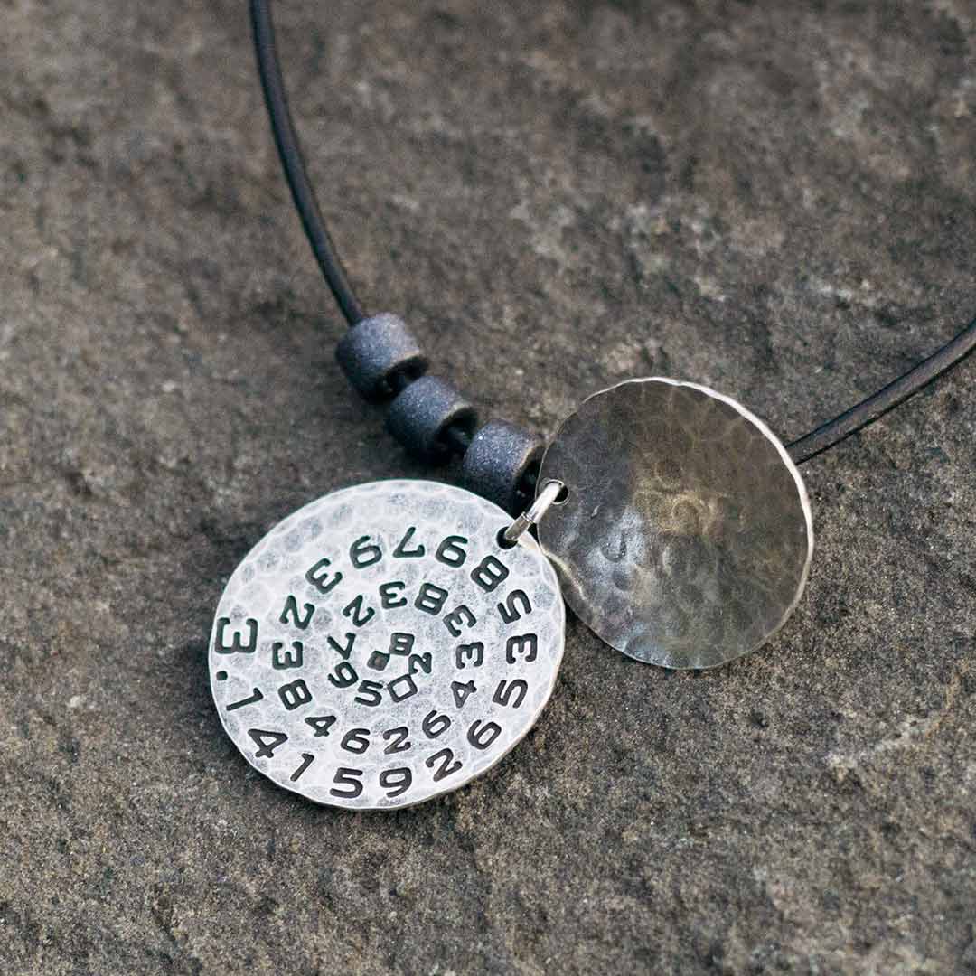 Pi math necklace showing the pi symbol on one disc and pi to 35 decimal places on the second disc. Great gift for a mathematician, a student or a teacher of mathematics. 