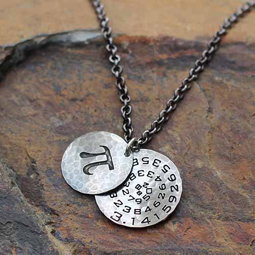 Pi math necklace showing the pi symbol on one disc and pi to 35 decimal places on the second disc. Great gift for a mathematician, a student or a teacher of mathematics. 