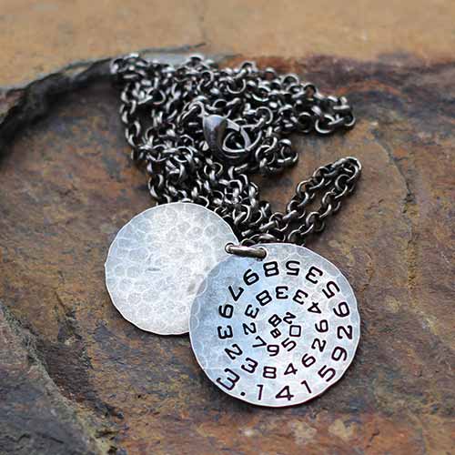 Pi math necklace showing the pi symbol on one disc and pi to 35 decimal places on the second disc. Great gift for a mathematician, a student or a teacher of mathematics. 